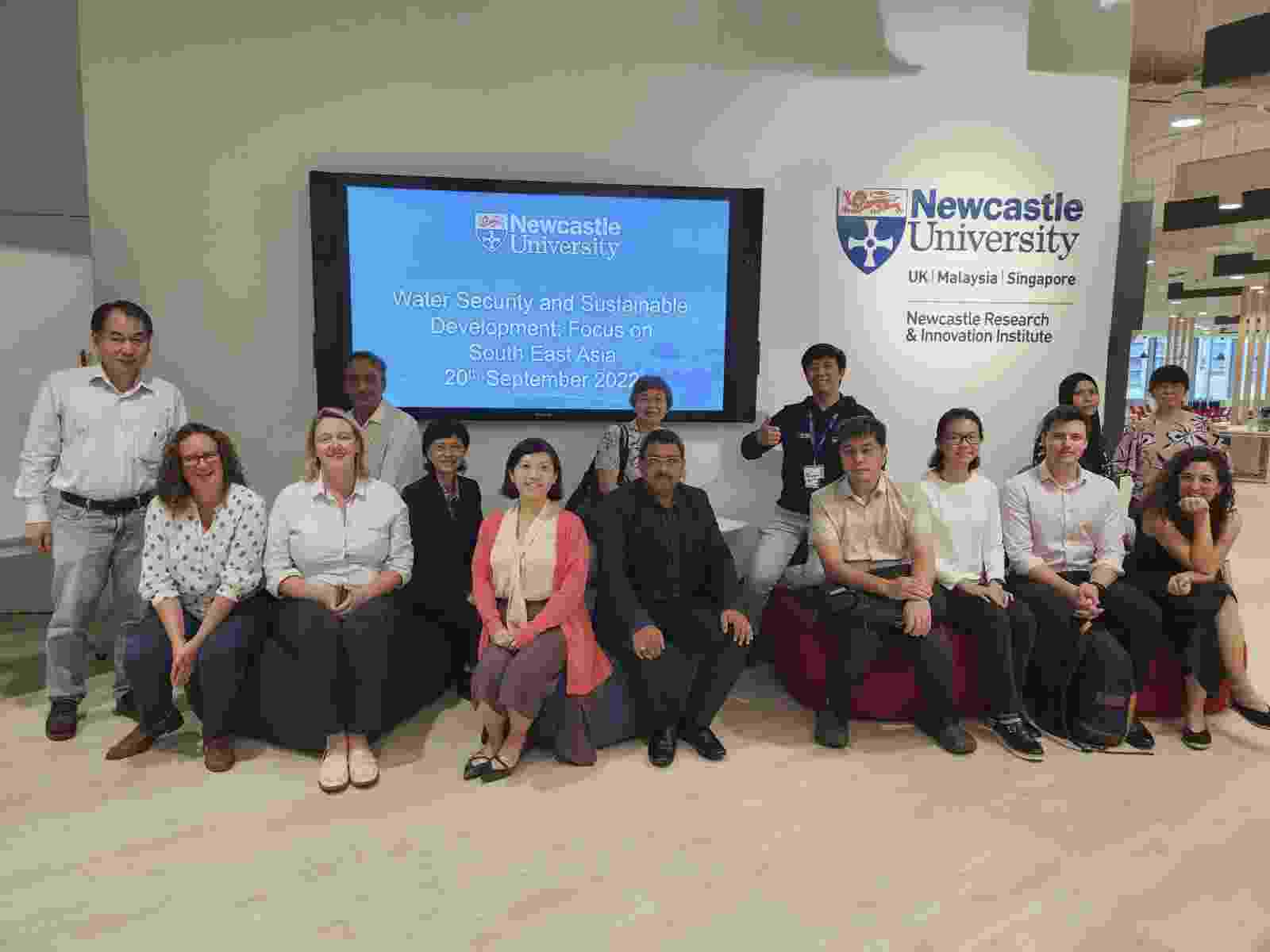 A mixed group of people sit together in front of a screen with the text 'Water Security and Sustainable Development: Focus on South East Asia'